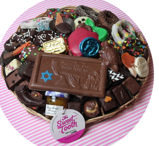 Assorted chocolates including a large chocolate bar with a Star of David on a pink striped background.