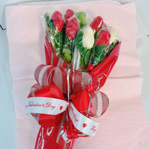 Bouquet of chocolate roses wrapped in red cellophane with decorative ribbon, perfect for Valentine's Day or romantic party celebrations.