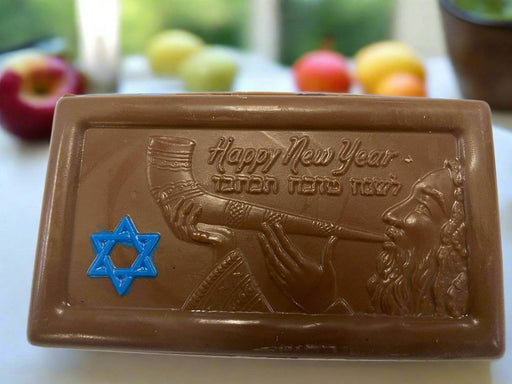 Rosh Hashana Chocolate Bar featuring a molded design of a man blowing a shofar with 'Happy New Year' text and a blue Star of David. Ideal for Jewish New Year celebrations.