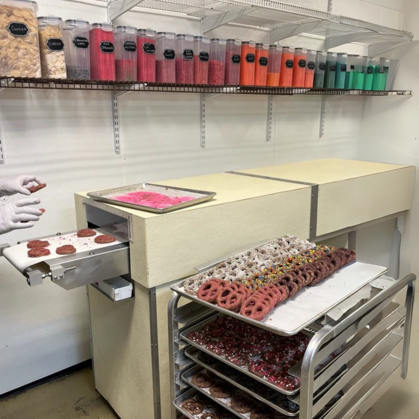 Chocolate dipped pretzels with assorted sprinkles on bakery racks The Sweet Tooth North Miami Beach since 1979