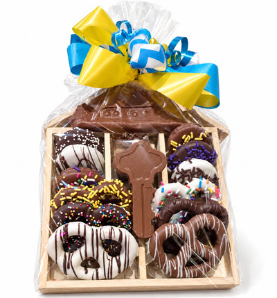 Housewarming chocolate tray with chocolate pretzels, Oreos, a chocolate house and key, wrapped with blue and yellow ribbon