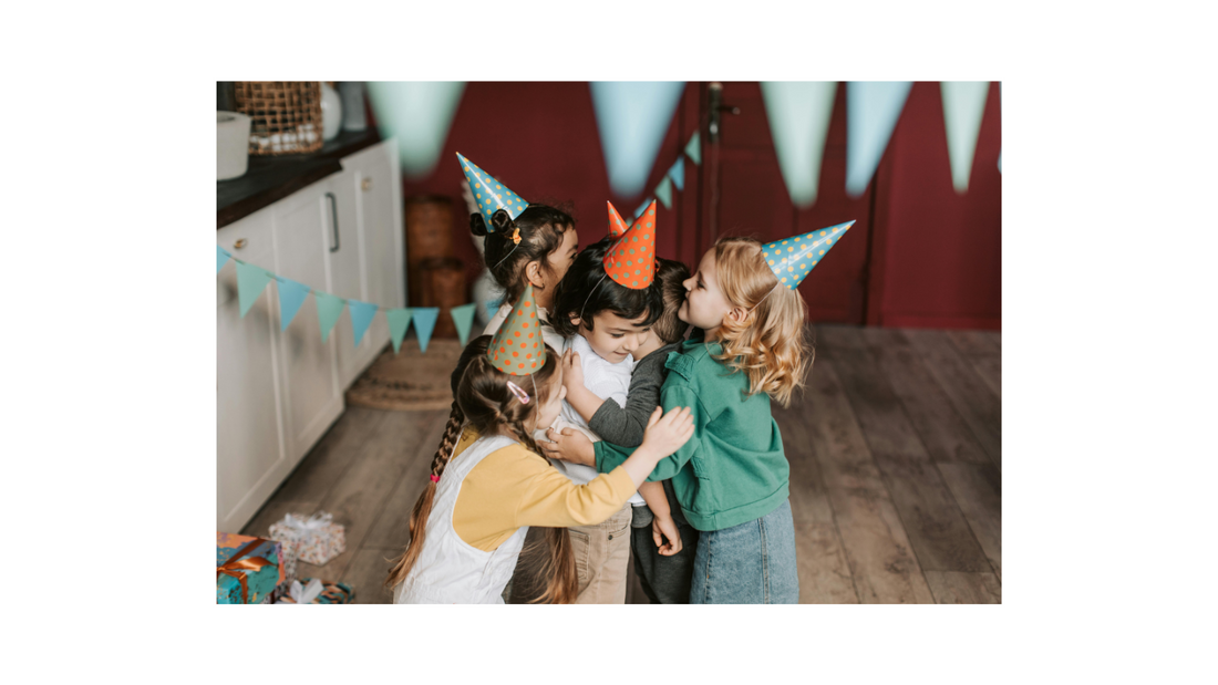 Children in party hats hugging at a joyful birthday celebration.