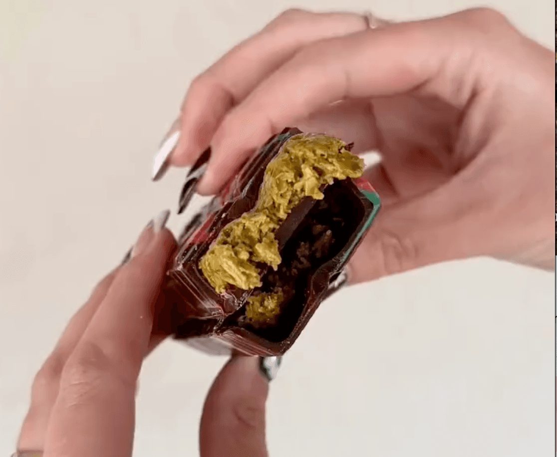 Passover Dubai Chocolate Bar with creamy pistachio butter filling shown in a close-up bite, highlighting its rich texture and unique layers.