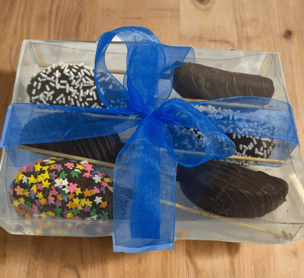 Chocolate Dipped  Apple Sticks 6-pack in clear gift box with blue ribbon, featuring assorted toppings like sprinkles and chocolate drizzle.