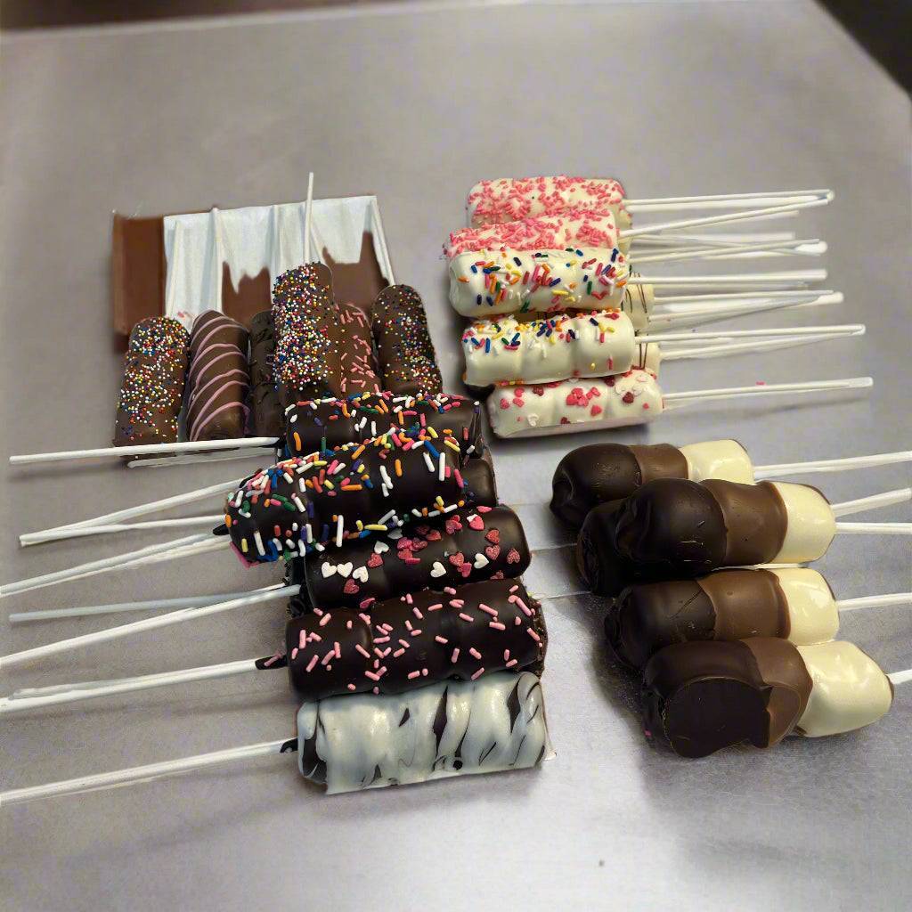 Variety of Passover chocolate-dipped marshmallow sticks arranged on a tray, featuring milk, dark, and white chocolate coatings.