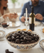 Bowl of chocolate shofars for Rosh Hashana  a table with people and wine in the background