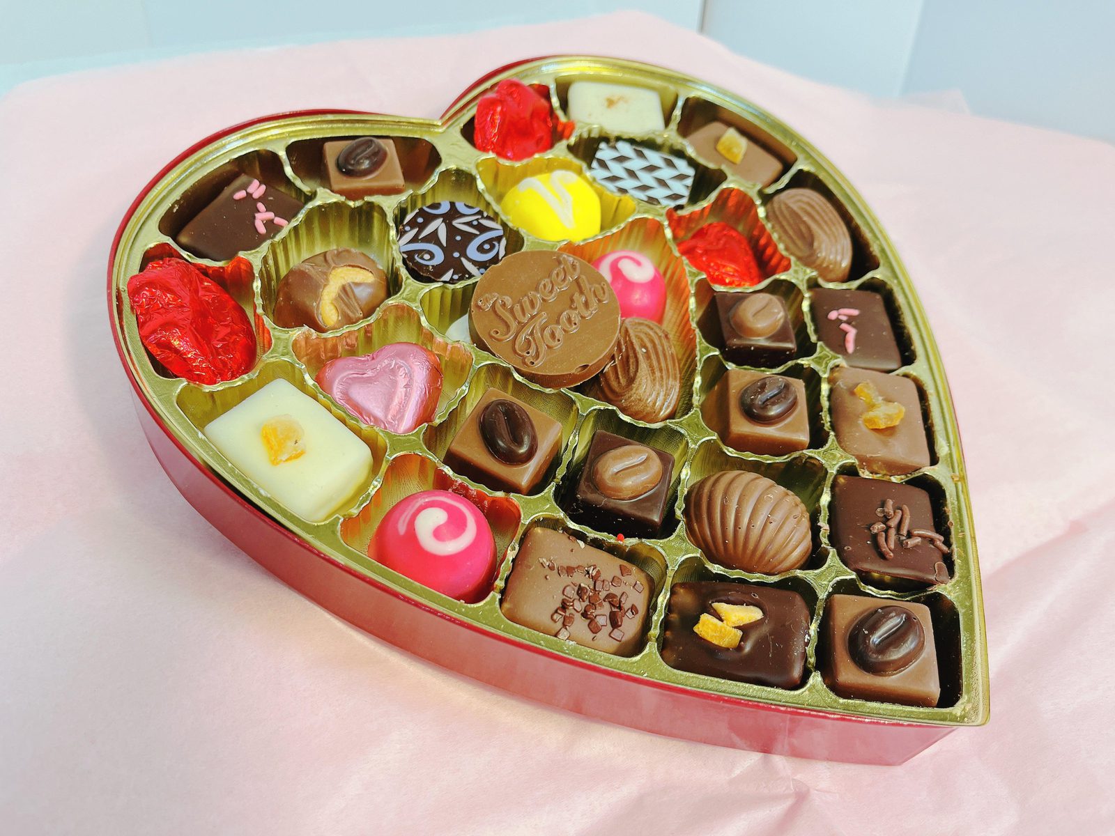 Heart-Shaped Box of Chocolates & Truffles filled with assorted gourmet treats including chocolate-covered fruit, ideal for gifting.