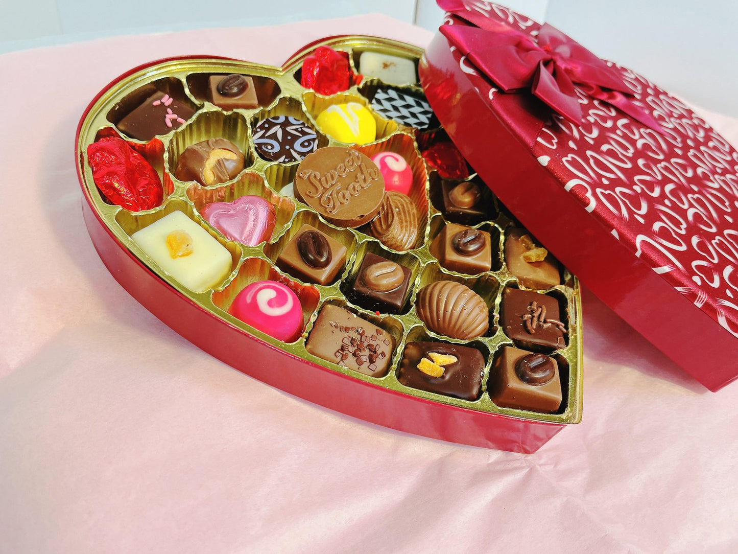 Angled view of Heart-Shaped Box of Chocolates & Truffles with open lid, revealing a variety of chocolate-covered fruit and truffles.