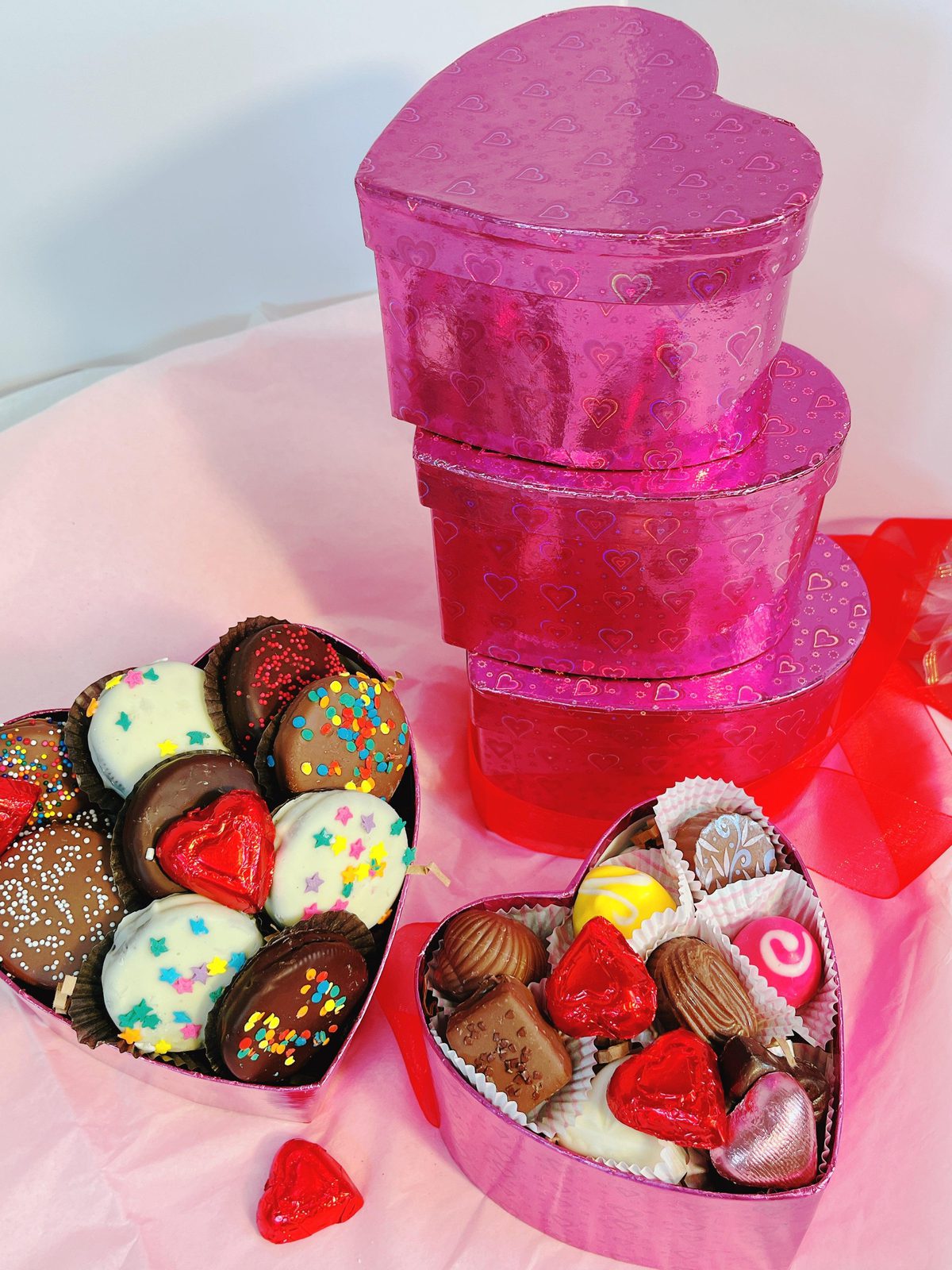 Elegant 3-tier heart-shaped gift boxes with gourmet chocolates and truffles, ideal for Valentine's Day or special celebrations.