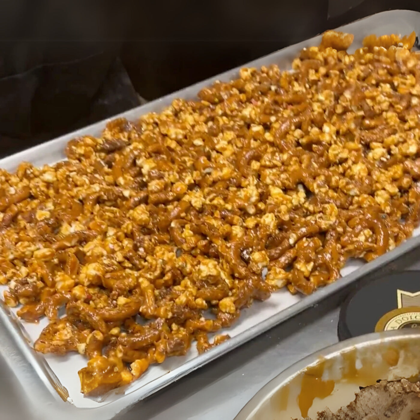 Tray of caramel corn on a white surface with a blurred background