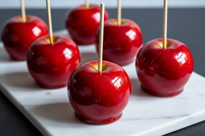 Classic Red Candy Apple with glossy red coating held by hand, showcasing nostalgic treat from the candy category.