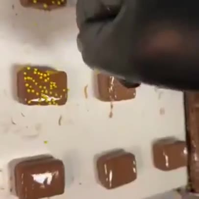 Peach truffles coated in chocolate on The Sweet Tooth enrober