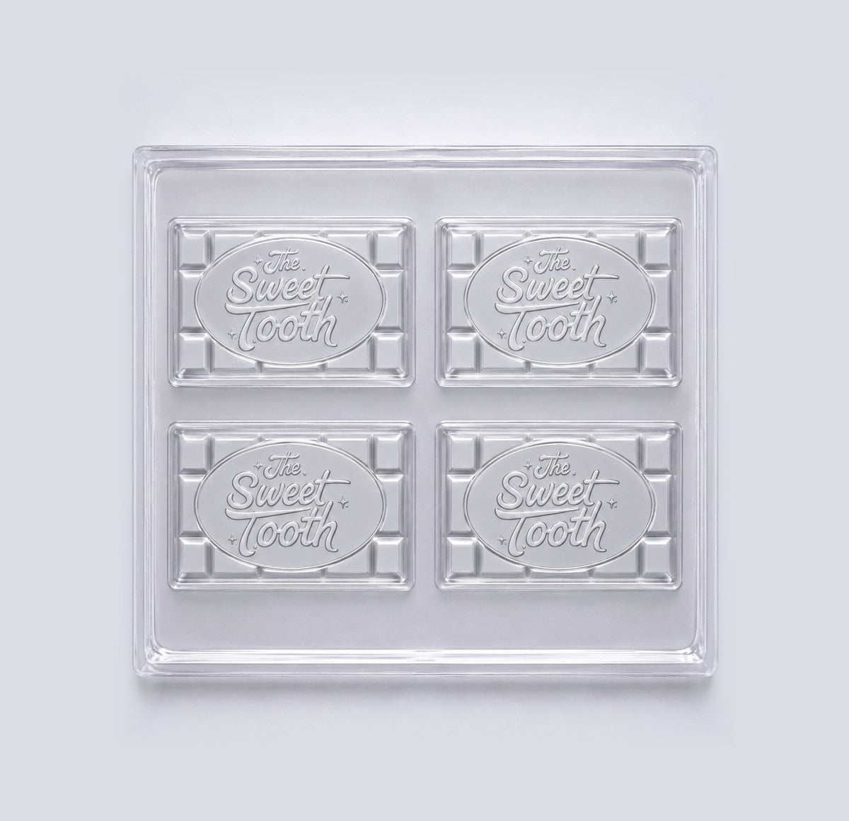 A clear 4-cavity chocolate bar mold with The Sweet Tooth logo in each cavity