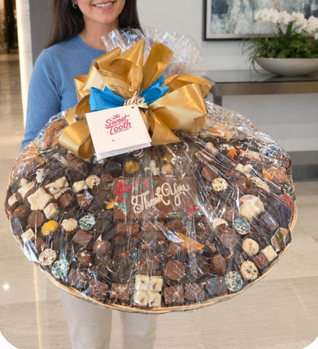 Customer holding a Penultimate chocolate gift basket wrapped in cellophane with a hand-tied bow